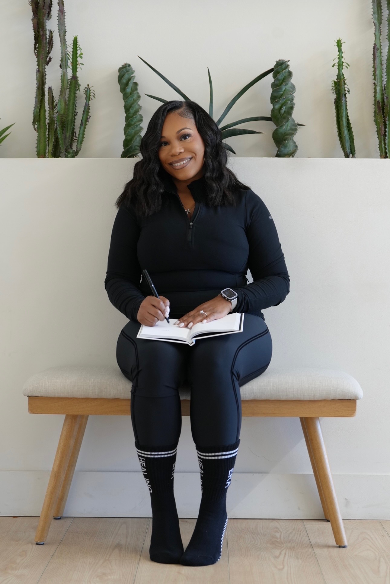 Brandi, founder of Elevate Wellness, journaling while wearing Healing Era grip socks